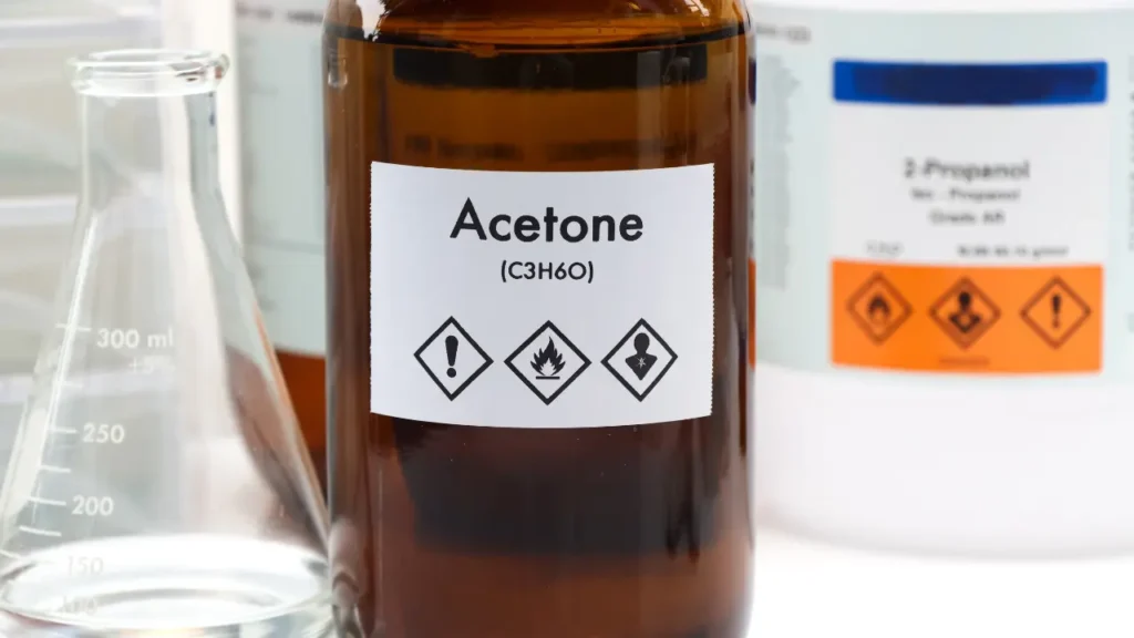 Bottle of acetone (C3H6O) with hazard warning labels, a common solvent for dissolving resin