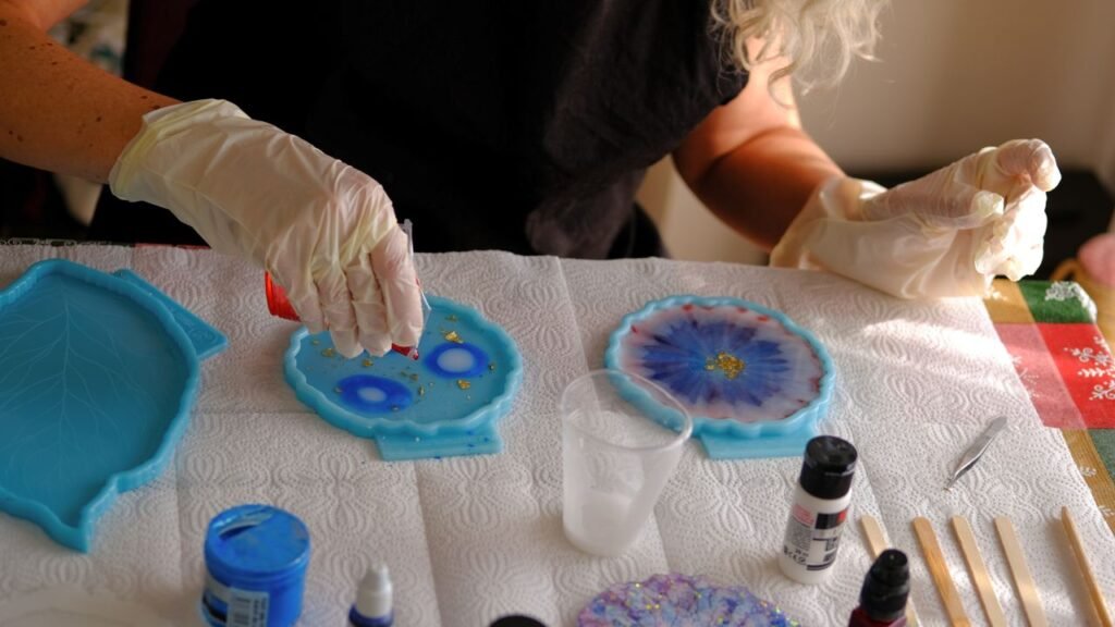Pouring blue resin with gold flakes into silicone coaster molds DIY craft"