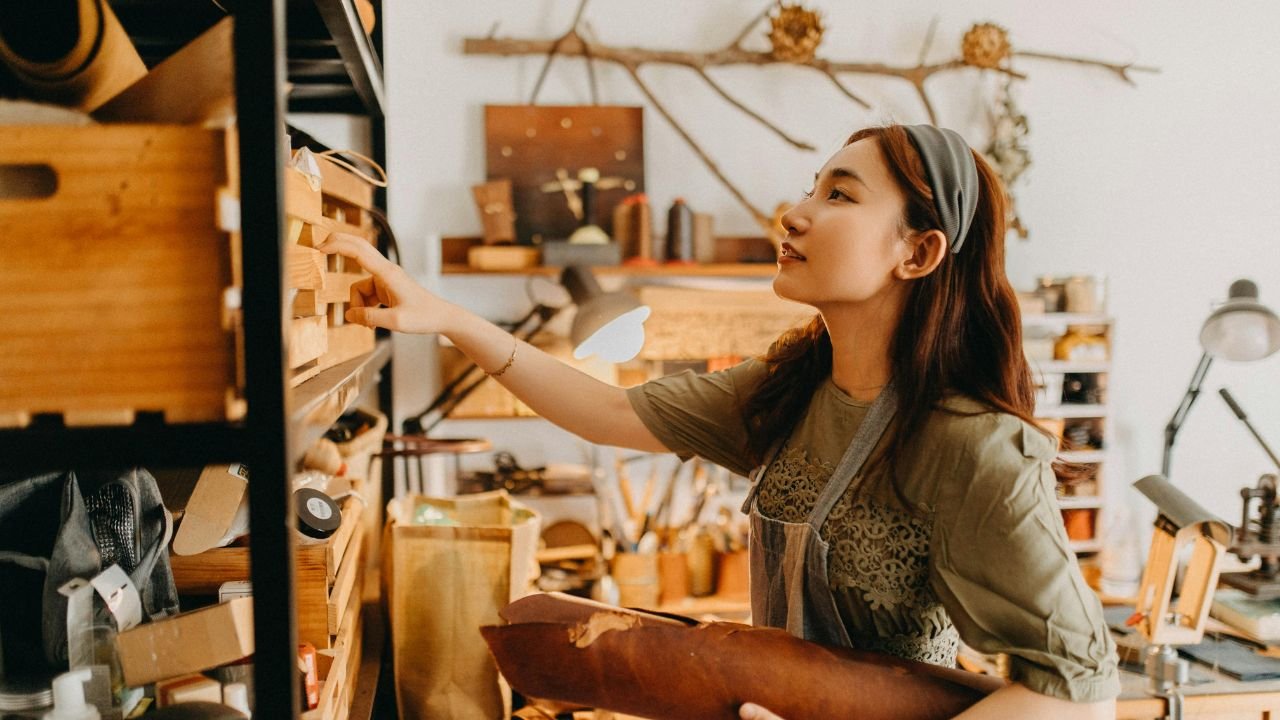 Woodworker browsing shelves of supplies and materials in a well-organized woodworking studio
